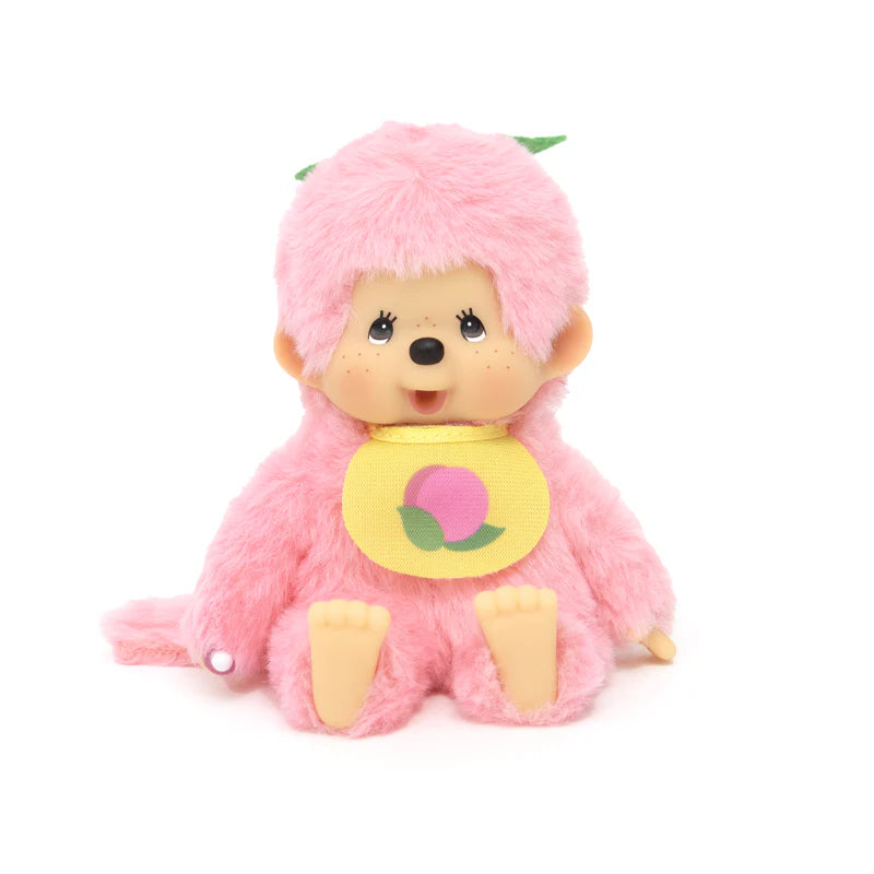 Monchhichi Fruit Beanies Plush: A 5.5 pink plush monkey with big eyes, wearing a yellow bib with a peach graphic and green leaf accents.