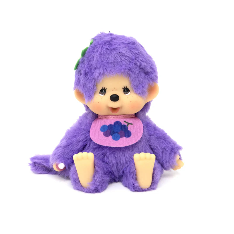 Monchhichi Fruit Beanies Plush doll with fuzzy purple fur, plastic features, and a pink bib with grapes, seated and ready for display.