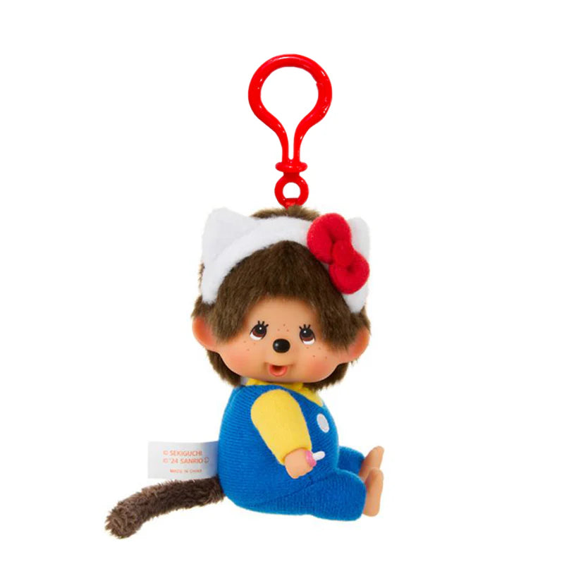 Hello Kitty x Monchhichi Big Head Plush Keychain: a small, brown-furred plush with a blue jumpsuit, cat-ear headband, and red clip for easy attachment.