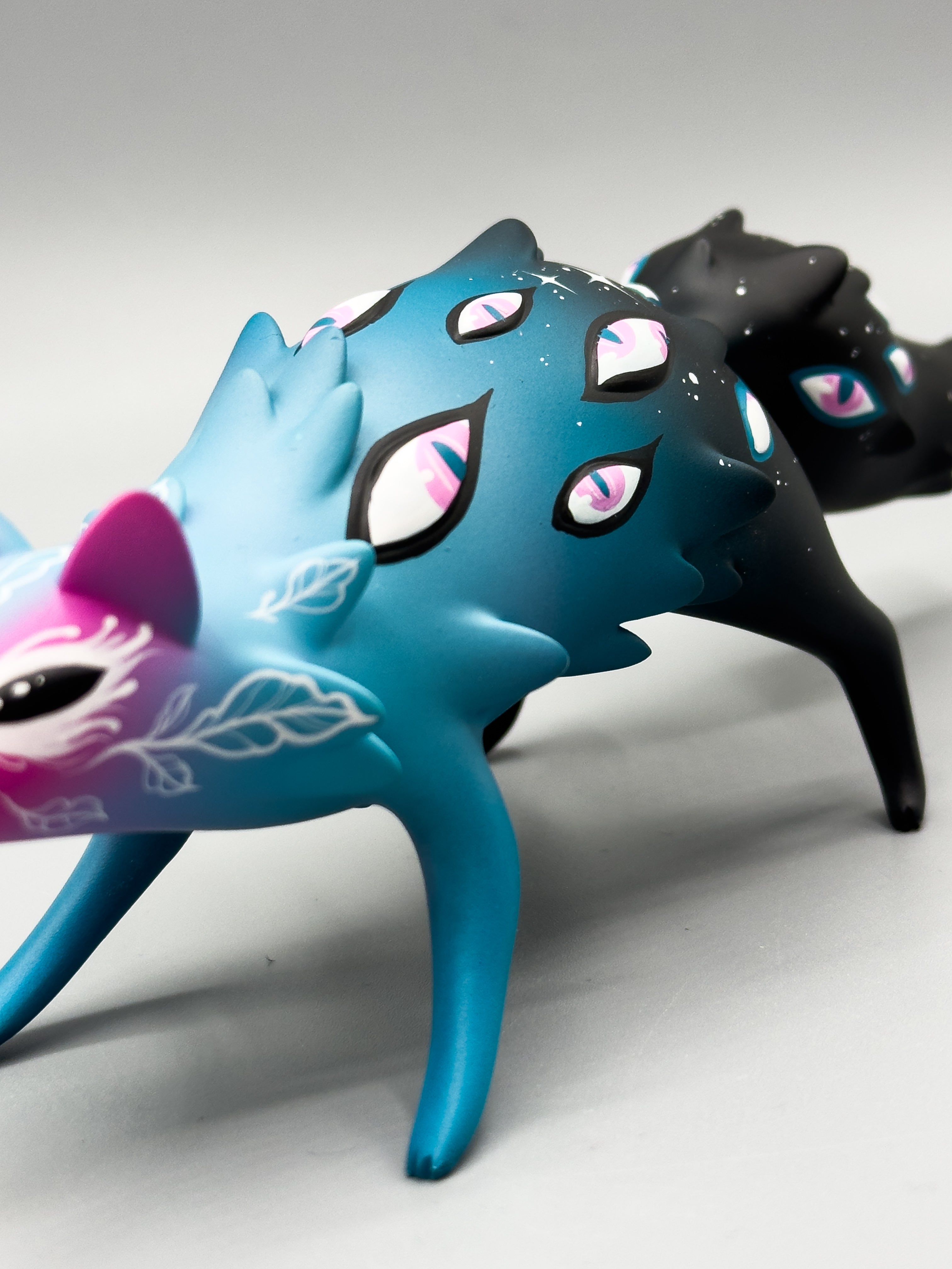 Two stylized fox-like art toys, Cosmyrr by Tomodachi Island x Faunwood, featuring multi-eyed designs, crafted from high-grade resin, 10cm tall.