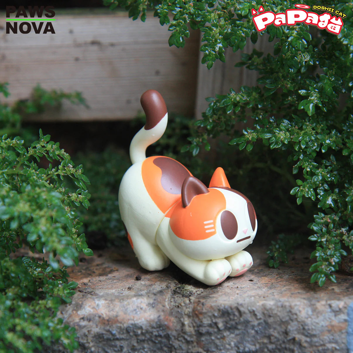 TROUBLE CREW PAPA CAT BLIND BOX figurine, styled as a stretching calico cat, on a ledge with PAWS NOVA and Doshi Cat PaPa branding.