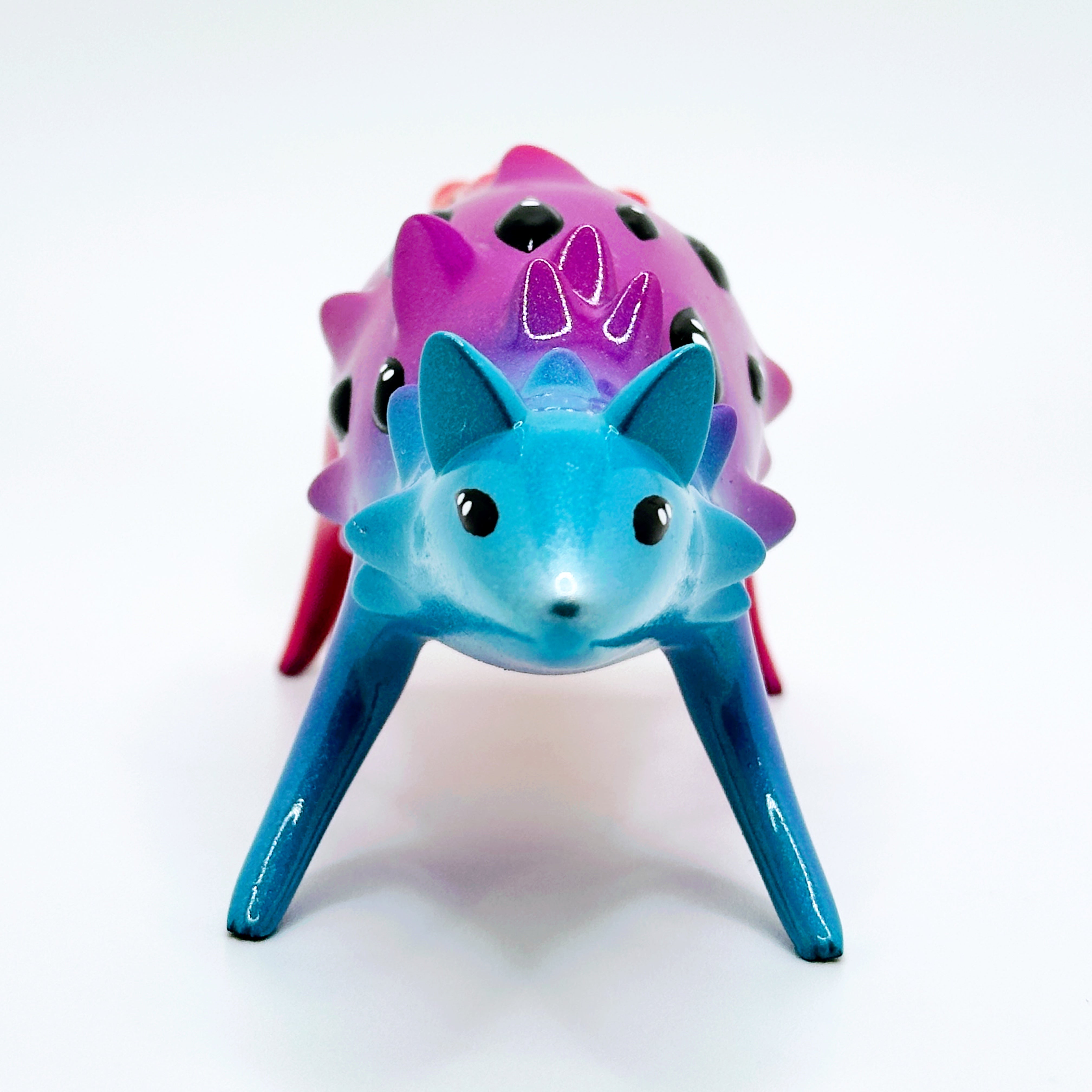Sunset Oracle figurine, a 10cm hand-painted resin toy by Tomodachi Island and Faunwood, featuring a spiky creature with a vibrant gradient design.