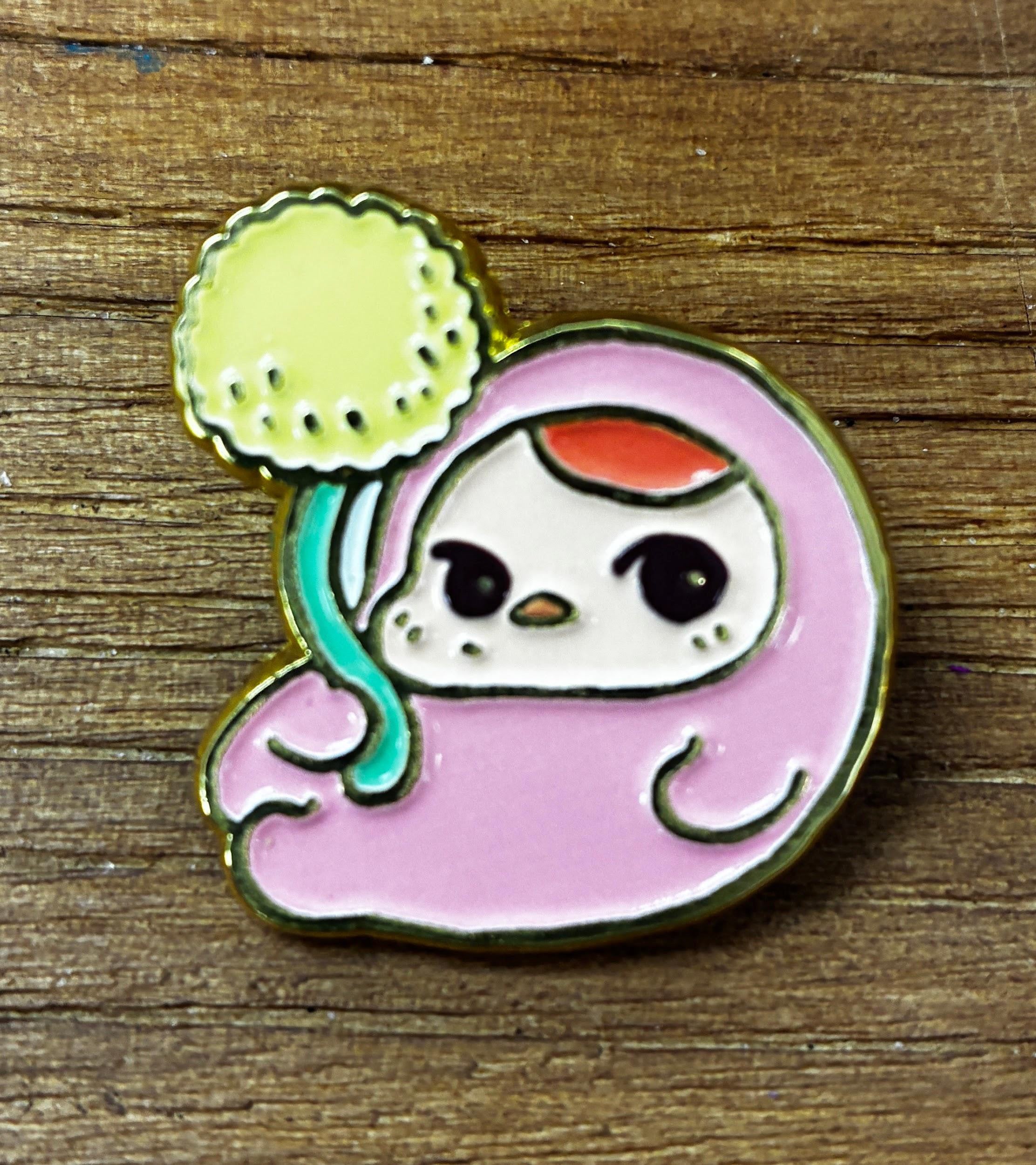 Bloom Pins by Pucky: A chubby cartoon creature enamel pin holding a dandelion puff, designed for collectors at Strangecat Toys.