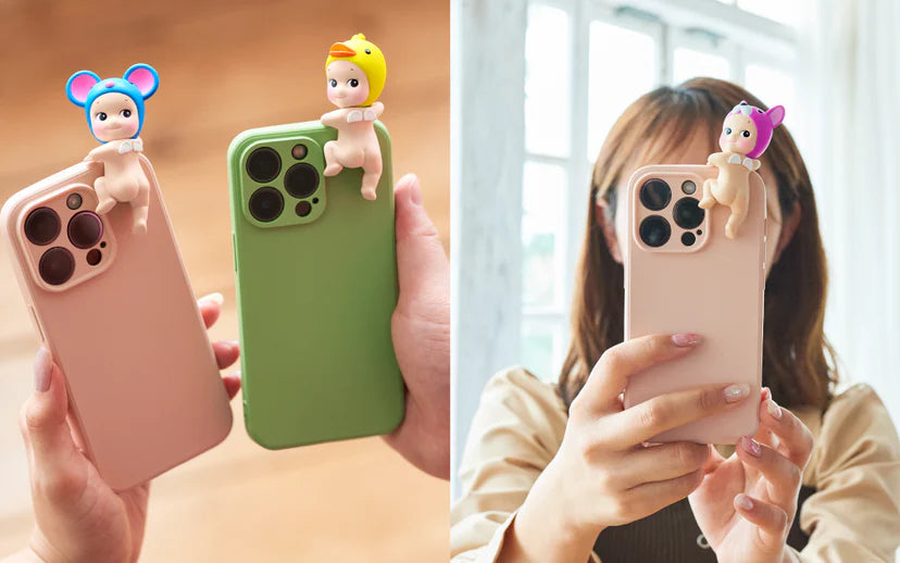 A person holds a green cell phone with Sonny Angel HIPPERS figures attached. Blind-boxed, these mini figures bring cute animal headgear styles to your space for sweet dreams.