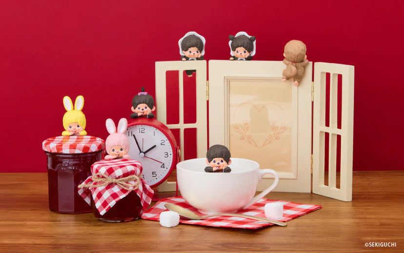 Monchhichi HIPPERS figures adorn teacup, jam jars, and alarm clock, showcasing their playful charm in a cozy breakfast setting.