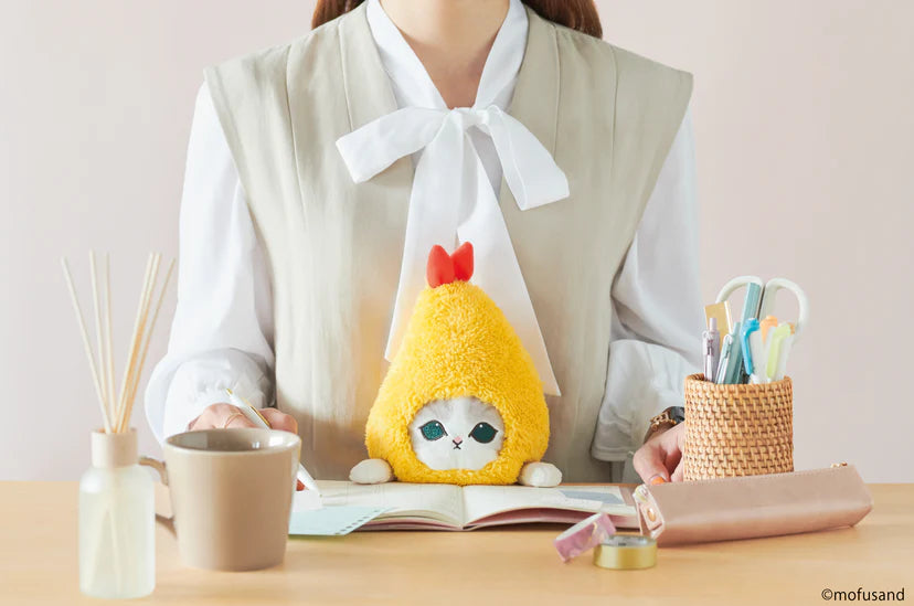 Posture Pal - mofusand: A woman uses a Shark Meow stuffed animal at her desk to support posture, an art toy from Strangecat Toys.