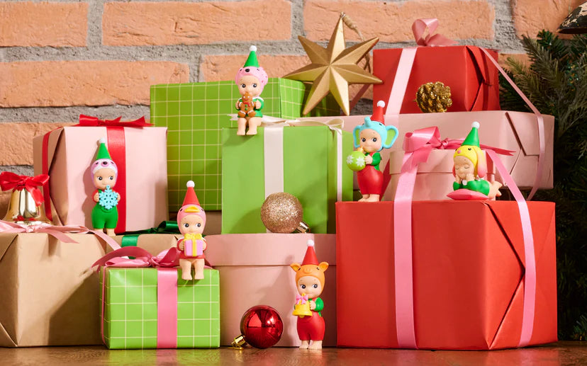 Santa's Little Helper Series figurines among wrapped gifts and Christmas decor, showcasing Sonny Angel elves ready to assist Santa.
