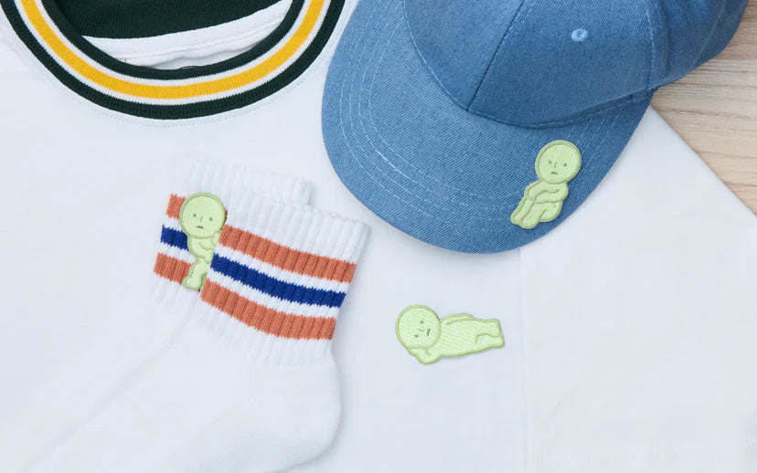 SMISKI Embroidery Sticker on cap and socks, with a T-shirt. Perfect for adding playful charm to your attire with these glow-in-the-dark appliqués.