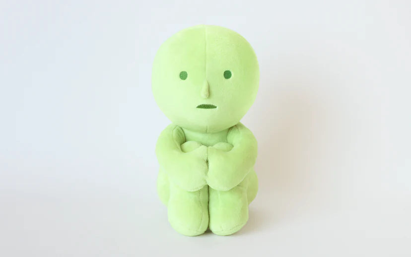 SMISKI Plush: A soft, lime-green doll with stitched features and folded arms, perfect for comfort and a tactile SMISKI experience.
