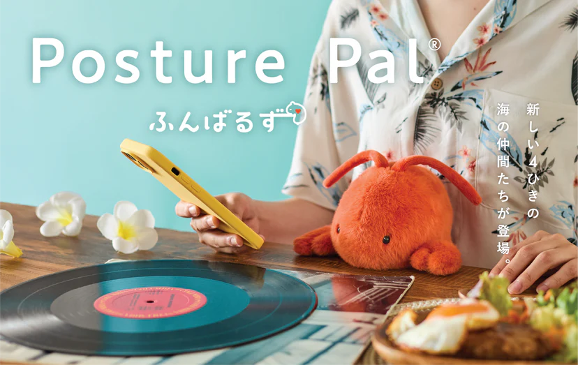 Posture Pal - Marine plush toy on a summery table, surrounded by plumeria flowers and breakfast, held by a person in a Hawaiian shirt.