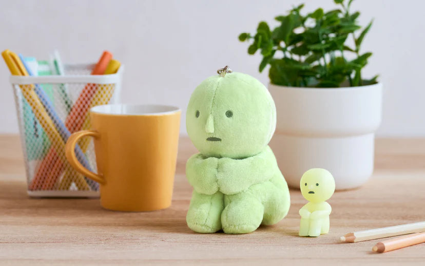 SMISKI Plush Keychain and figurine on a desk with a coffee mug, pens, and plant, highlighting quirky art toys from Strangecat Toys.