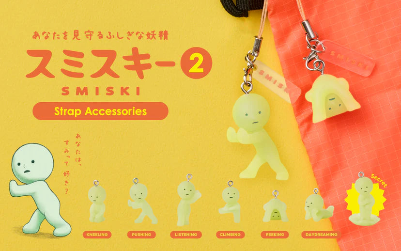 SMISKI Strap Accessory - Series 2: Seven mini glow-in-the-dark figures, including one secret, shown in various poses clipped onto an orange bag.