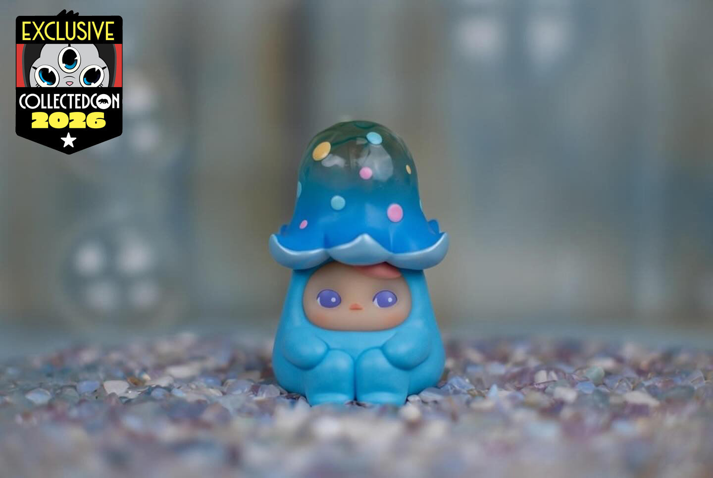 Chibi vinyl figure Blue Loliboom by Pucky in a jellyfish suit, posed on polished stones; Collectible exclusive to CollectedCon 2026.