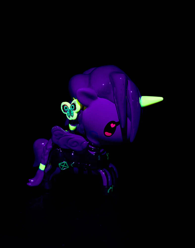 tokidoki x ARCANE Unicorno Black Light Chrome Blind Box figure, featuring a deep purple body with glow-in-the-dark neon accents under UV light.