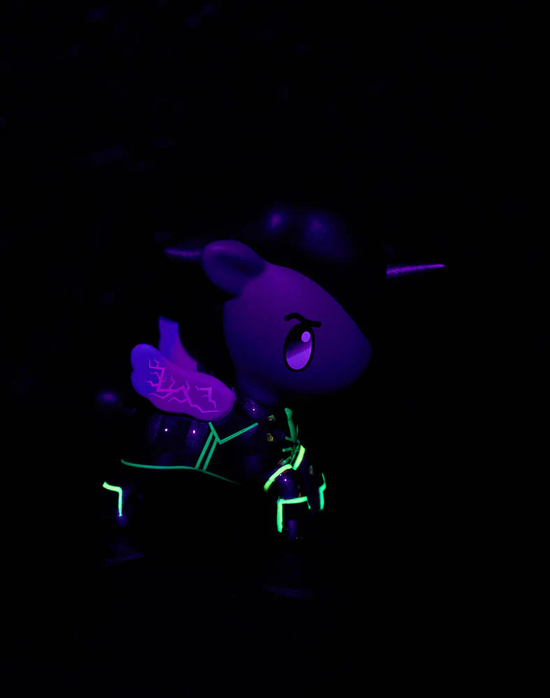 Tokidoki x ARCANE Unicorno Black Light Chrome Blind Box figurine, glowing purple-green under UV light, showcasing wings, horn, eyes, and stylized armor details.