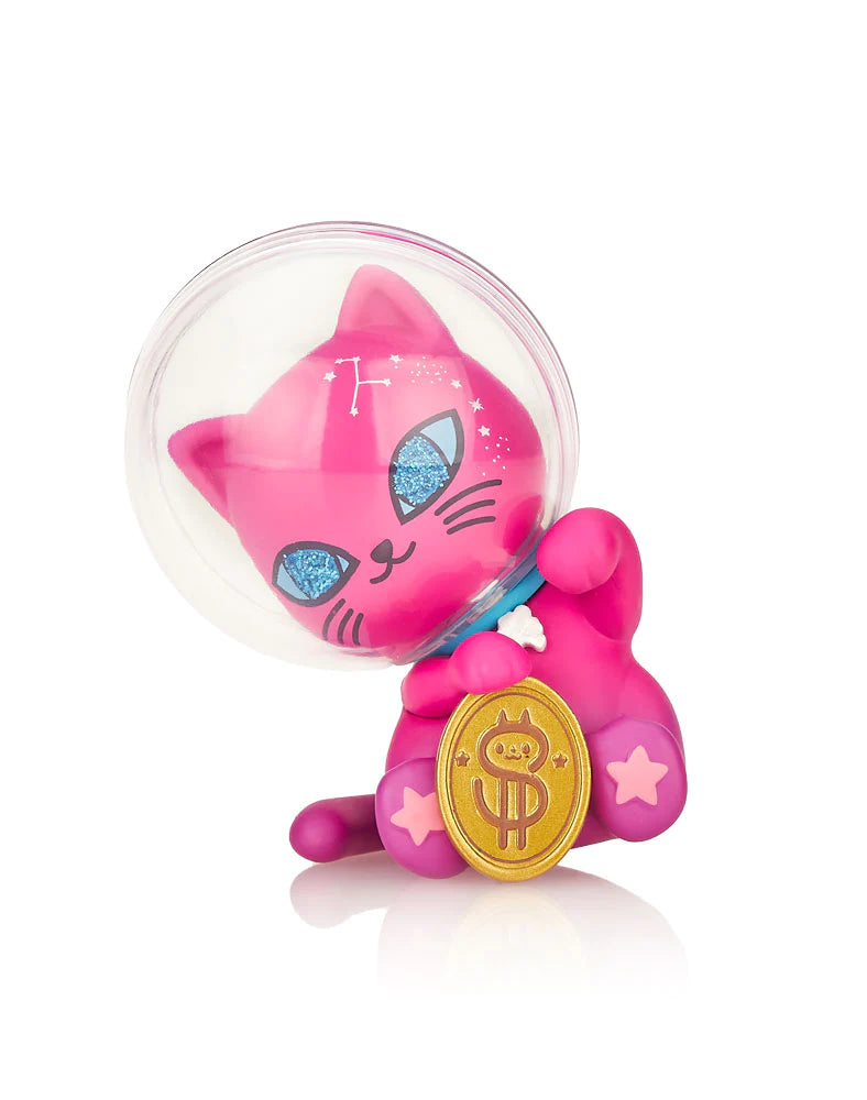 A pink cat toy with a gold coin, part of the Galactic Cats Blind Box series featuring extraterrestrial feline characters like Purriwinkle and Astrocat.
