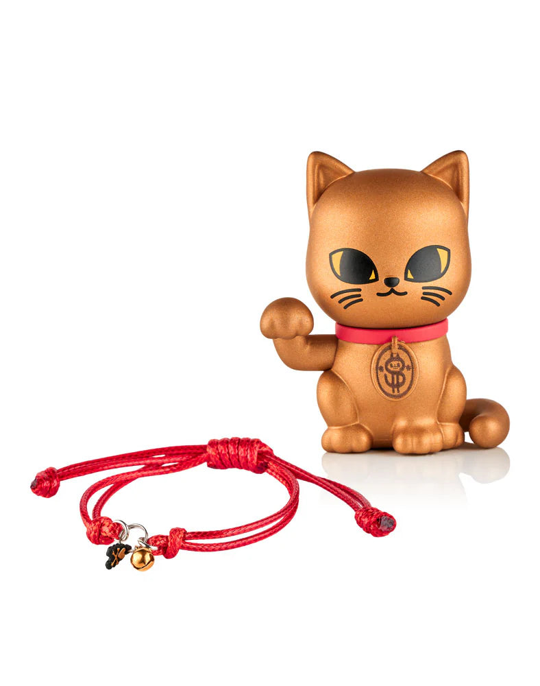 Gold-painted Maneki-neko figurine with a red collar and coin emblem, accompanied by a red cord bracelet featuring a bell and clover charm.
