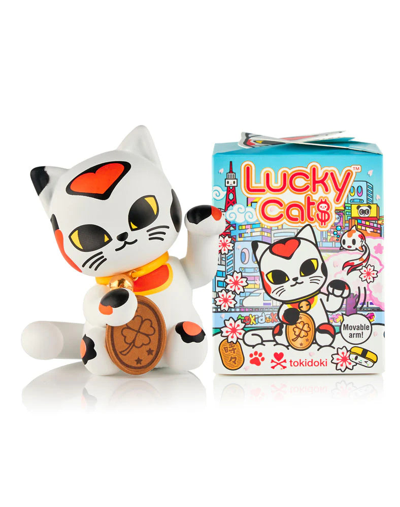 tokidoki “Lucky Cat$” vinyl figure, styled as Maneki-neko, with movable paw and coin, next to its colorful box featuring Lucky Cat$ logo and cherry blossoms.
