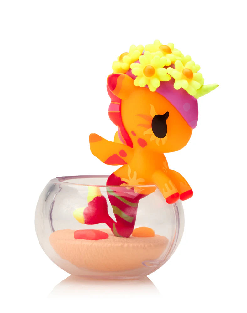 Neon Reef Mermicorno Blind Box features a colorful fantasy creature perched on a glass bowl rim, with coral decorations inside. Collectible art toy from Strangecat Toys.