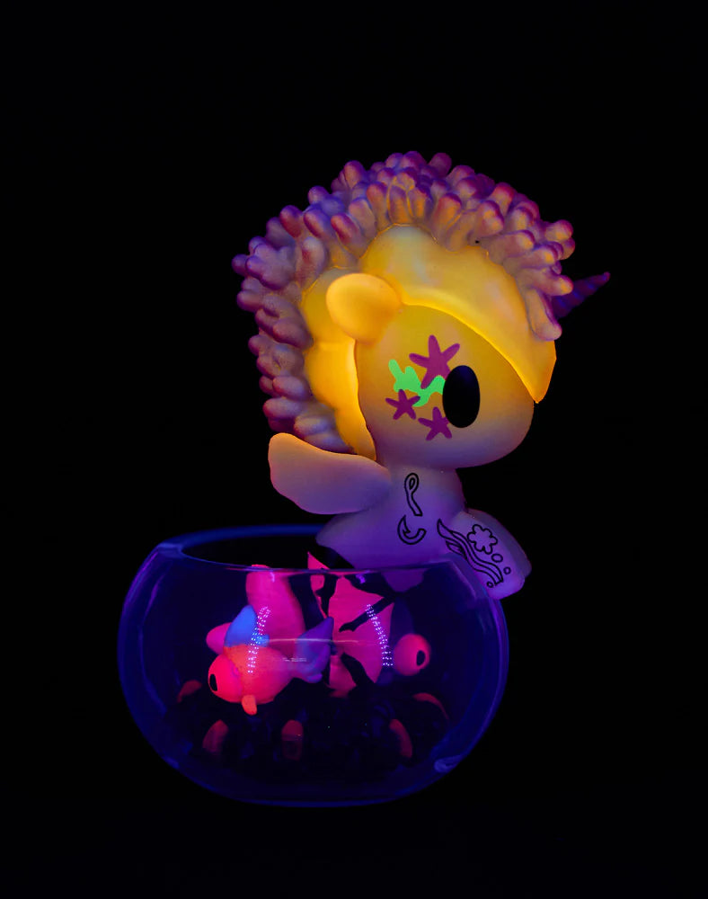 Neon Reef Mermicorno Blind Box figurine with UV-reactive mane and fluorescent toy fish, glowing vividly under blacklight. A collectible from Strangecat Toys.