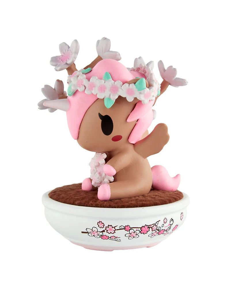 Botanical Bonsai Unicorno Blind Box figure: a chibi deer/unicorn hybrid with cherry-blossom accents, seated in a sakura-patterned bowl.