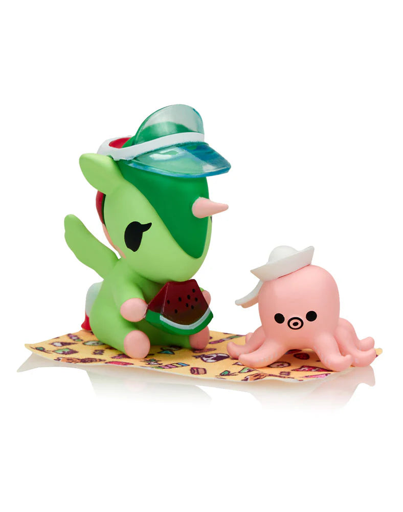 Fun In The Sun Unicorno Blind Box: Mint-green unicorn and pastel-pink octopus enjoying a picnic, showcasing whimsical beach-themed collectible figures from Strangecat Toys.