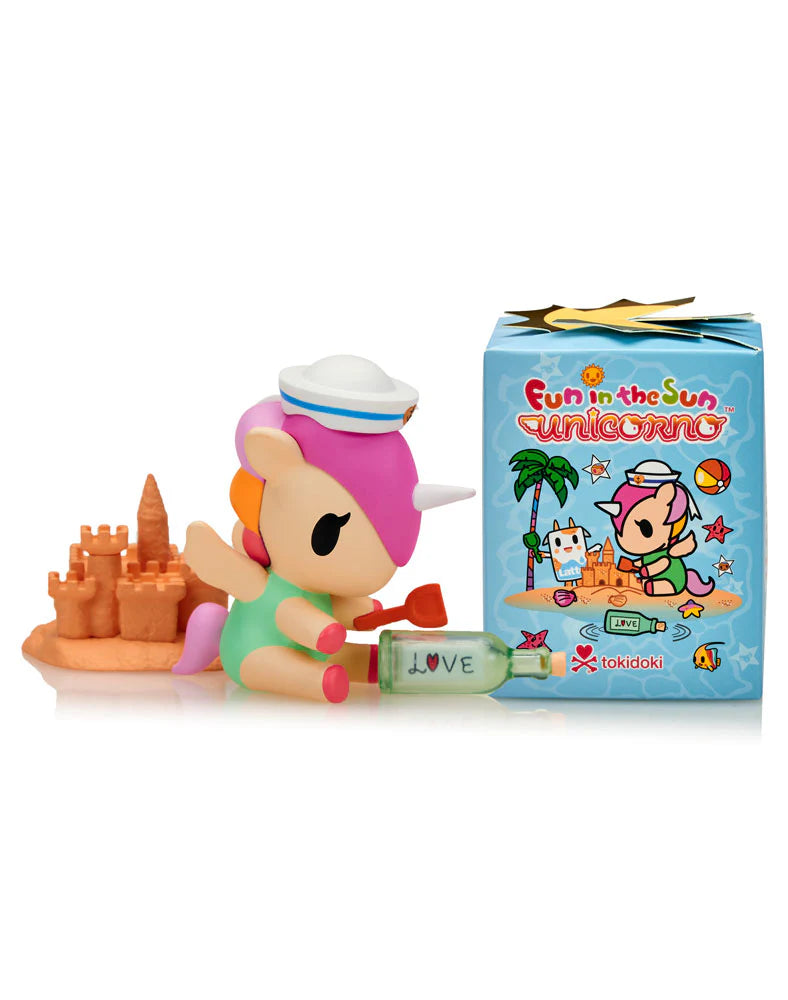 Fun In The Sun Unicorno Blind Box: Pastel unicorn with sailor cap on beach, sandcastle, shovel, and bottle labeled “LOVE”; matching illustrated box beside it.