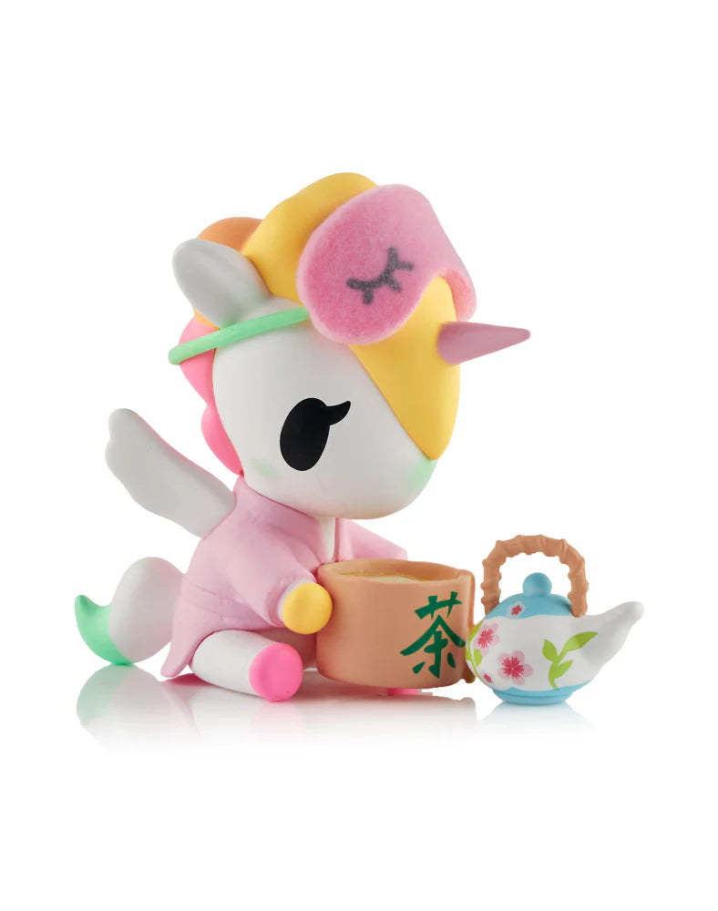 Spa Day Unicorno Blind Box figurine, featuring a unicorn in a pink bathrobe holding a kanji-marked tea bowl, with a floral teapot beside it.