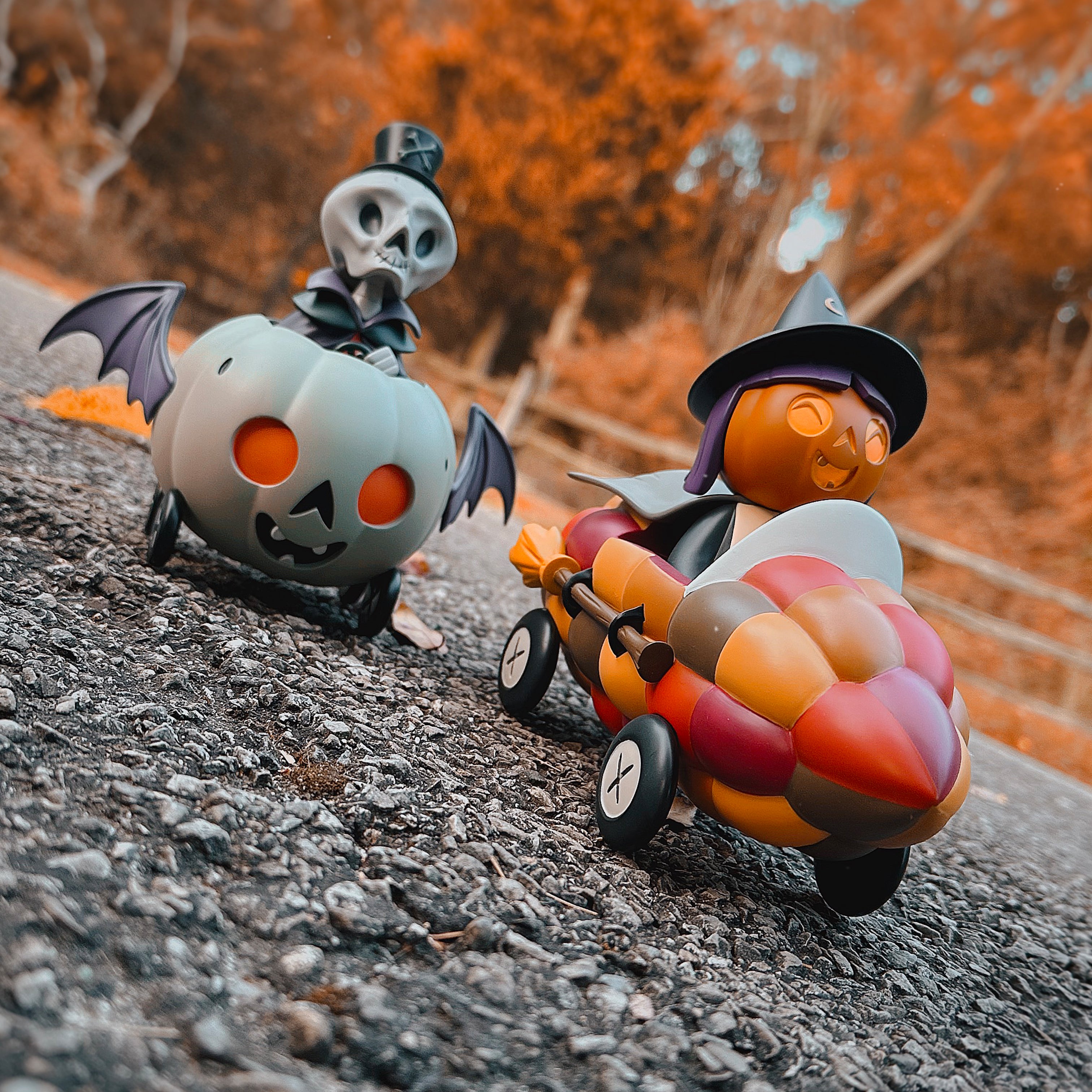 The Corny Cruisers by Stephanie Buscema: Two whimsical toy cars, featuring a witch and pumpkin theme, crafted from high-grade resin as limited-edition art toys.