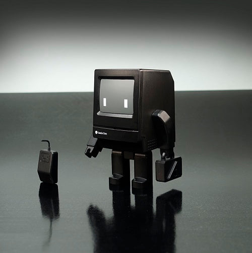 Classicbot toy robot with square face and head, holding a font suitcase and detachable arms, accompanied by a friendly mouse.