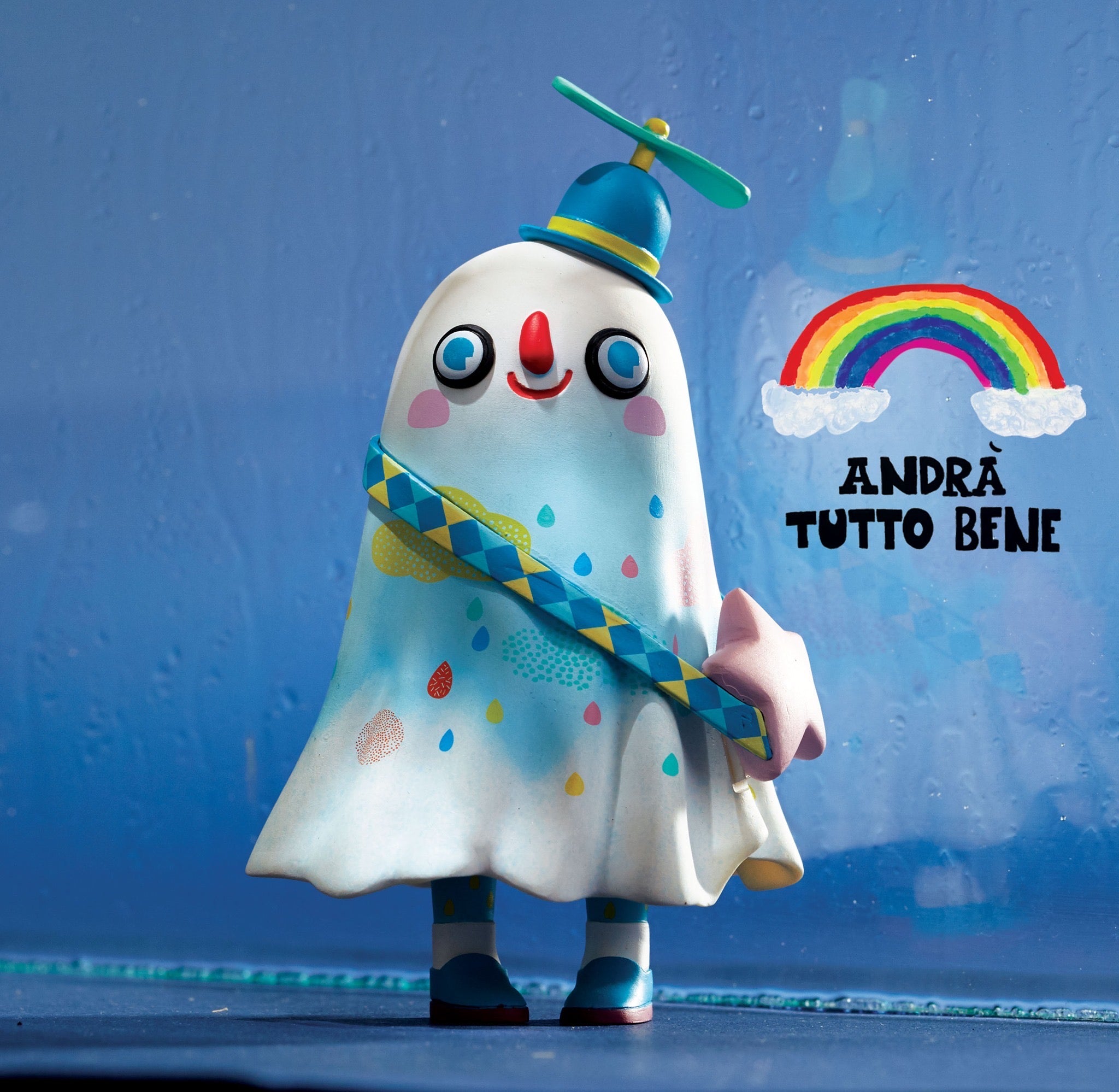 Toy figurine of a person in a cape and a ghost with a hat and stick, alongside a propeller and other playful elements.