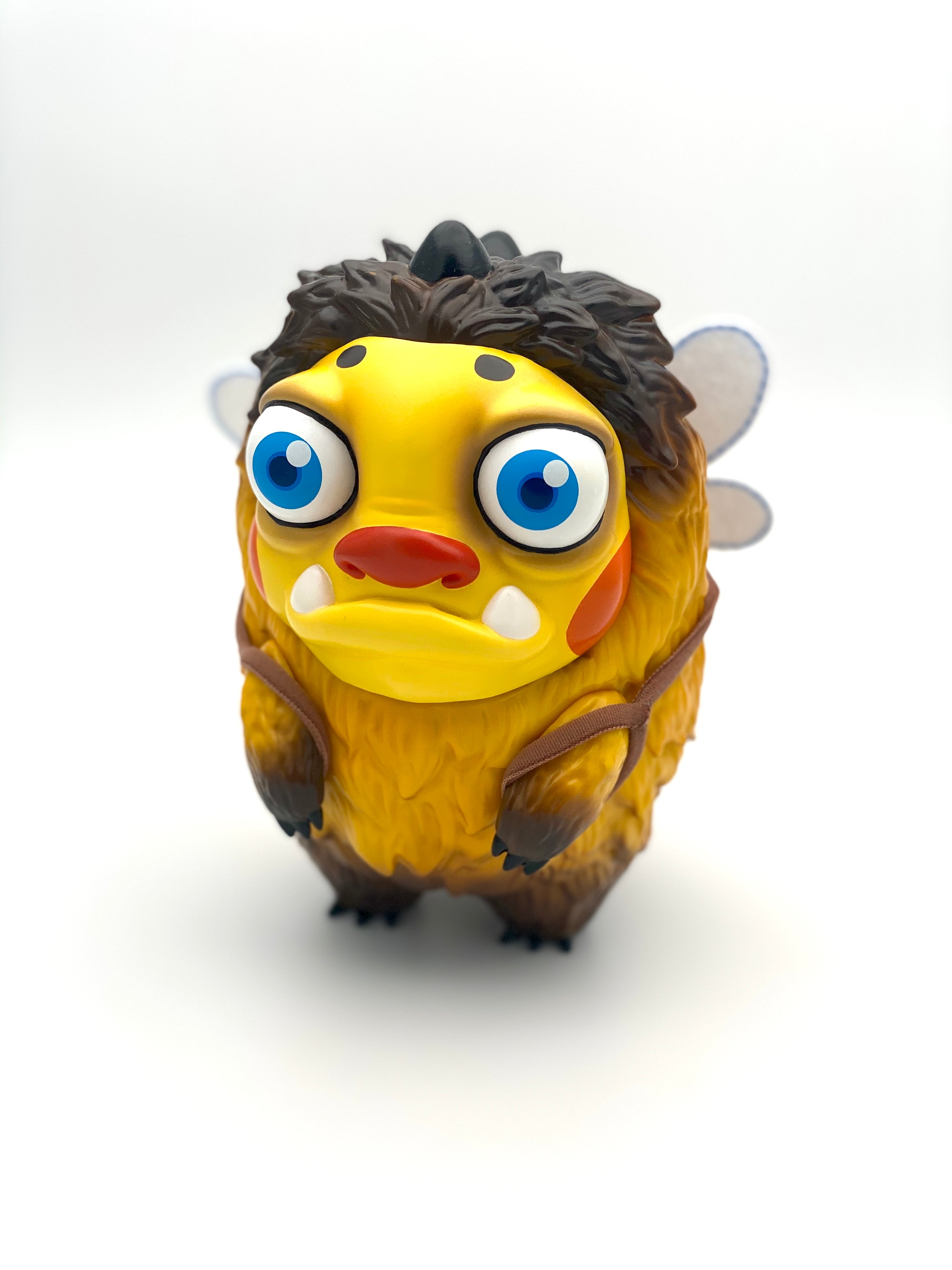 Cartoon toy with wings and oval object, close-up of eyes and white egg.