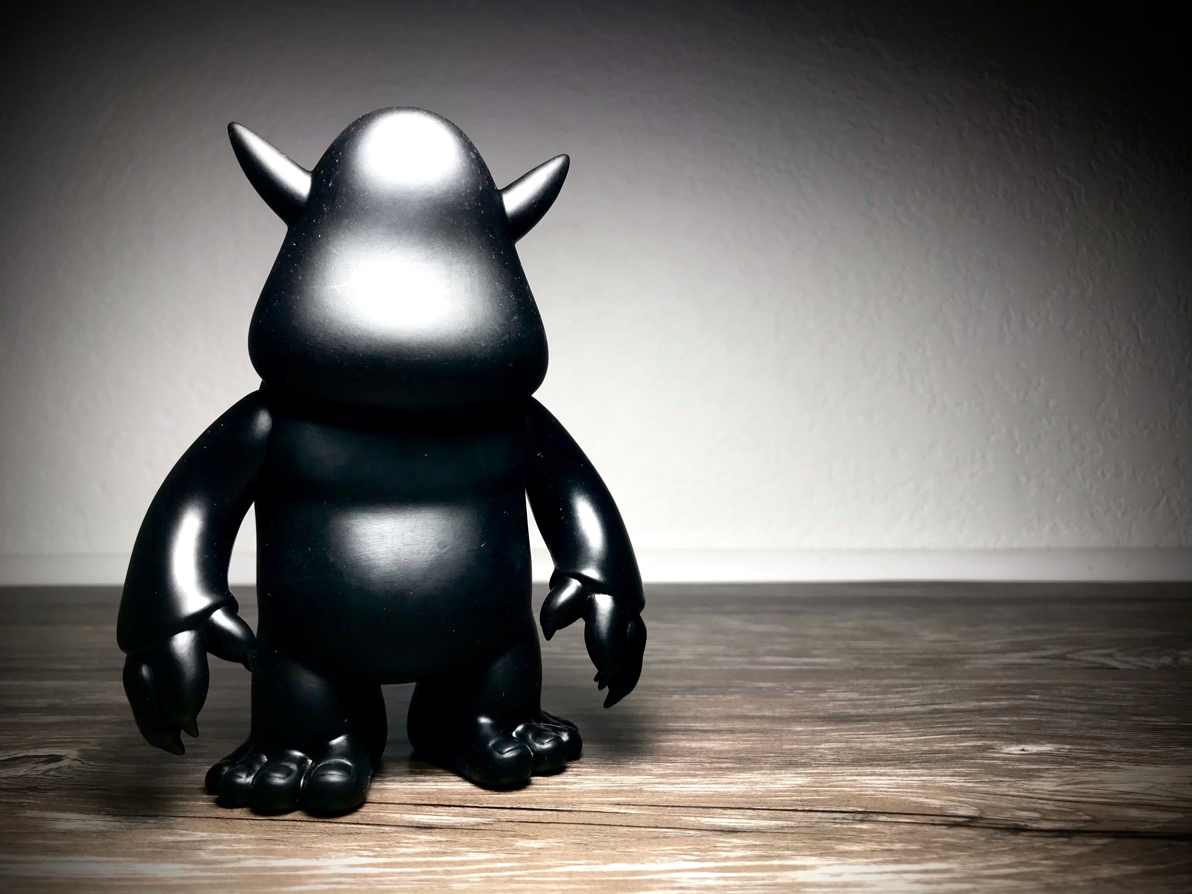 Stroll DIY Black Vinyl figurine with horns and detailed features on wood surface.