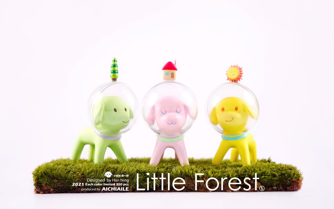 A group of small plastic animals in space suits, including a pink toy dog in a bubble and a yellow toy in a space suit, part of the Space Dog - Little Forest series by Han Ning.