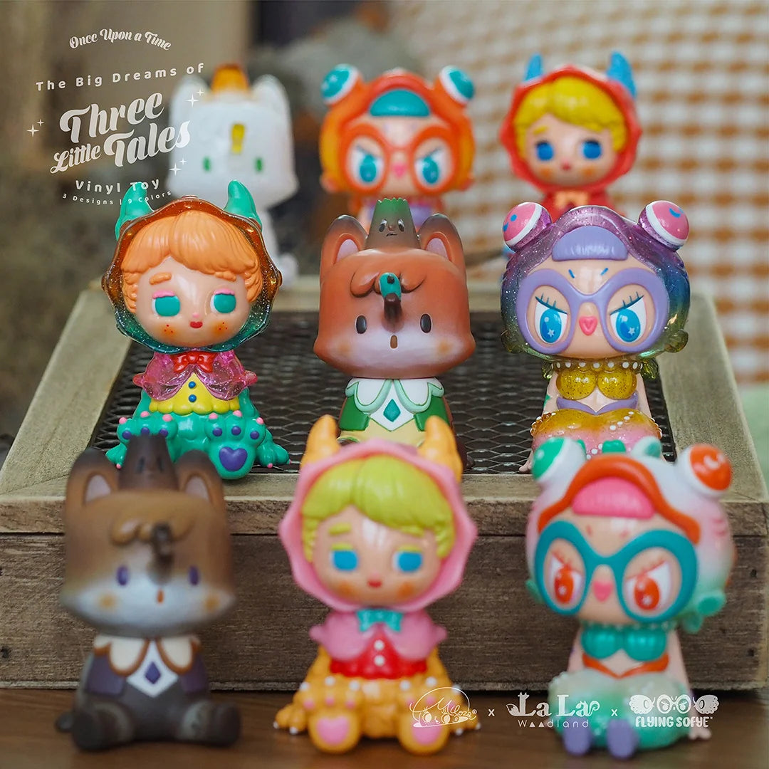 A group of small figurines, including a toy with a cartoon face and toy figurines of girls, part of the Three Little Tales - Blind Box Series by Miloza Ma.