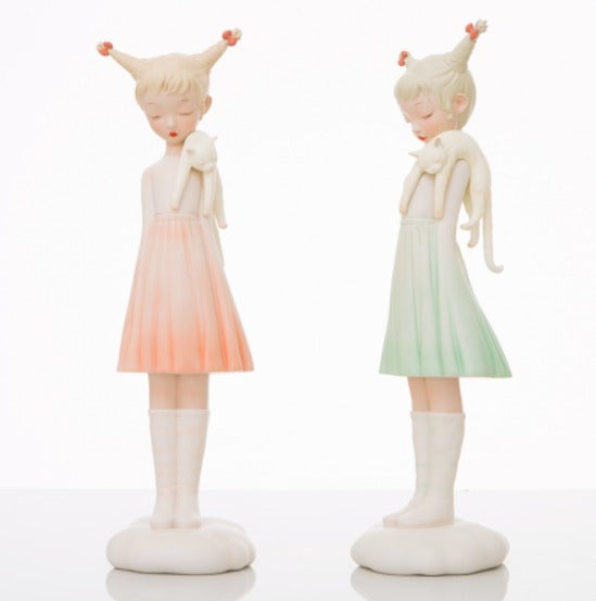 A figurine of a girl holding a cat, dressed in a white dress, part of the White Night Fairy - Cat and Cat collection by Steven Jia.