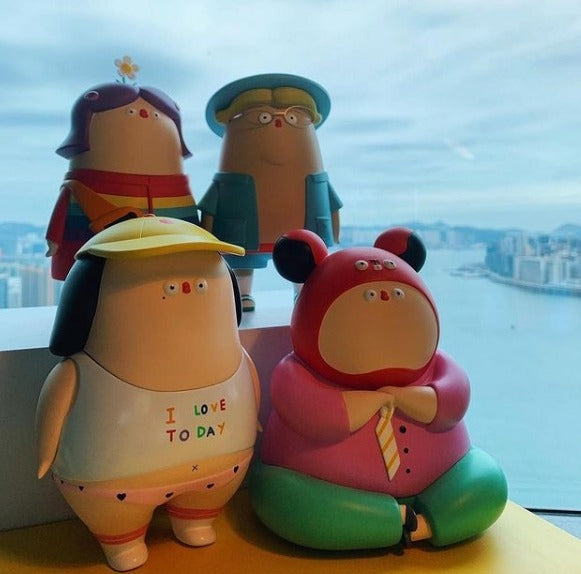 Best Mates by Flabjacks: A group of cartoon figurines, including a toy figure with a hat and glasses, a toy penguin in a shirt, and a cartoon character figurine, with a close-up detail of a toy.