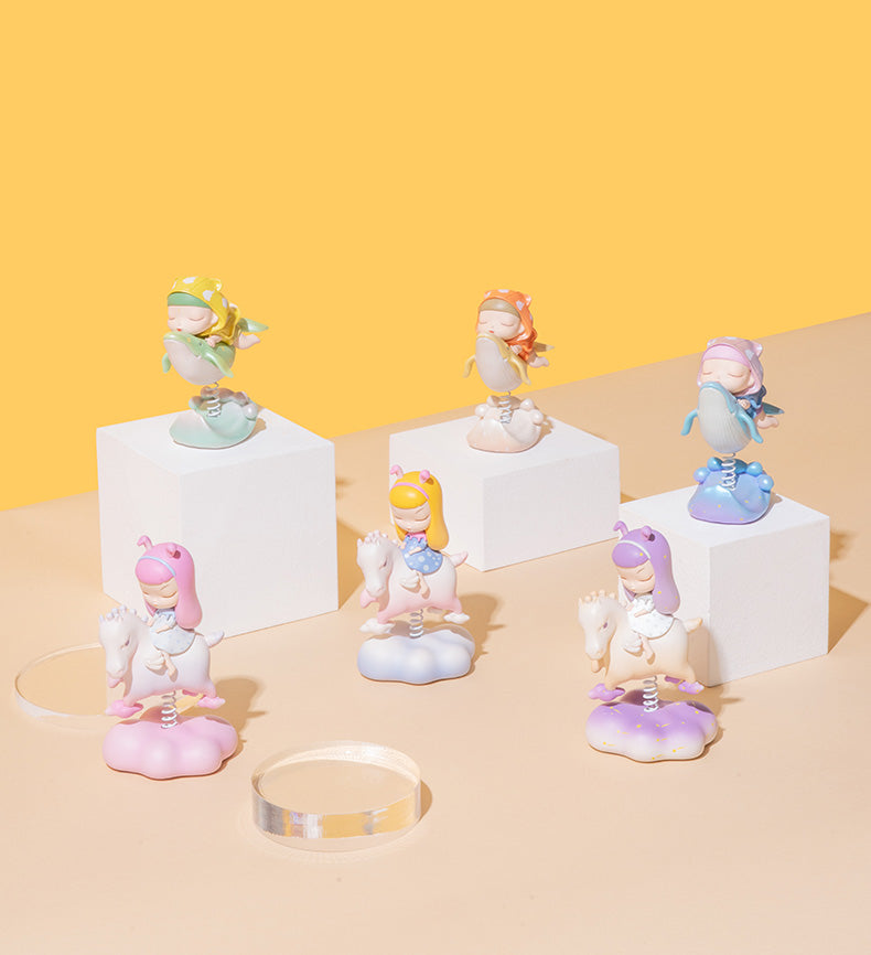 Shake! Shake! Shake the Fairy Series toy on spring, small figurines and statue on white cubes and spring, and close-up of a plate.