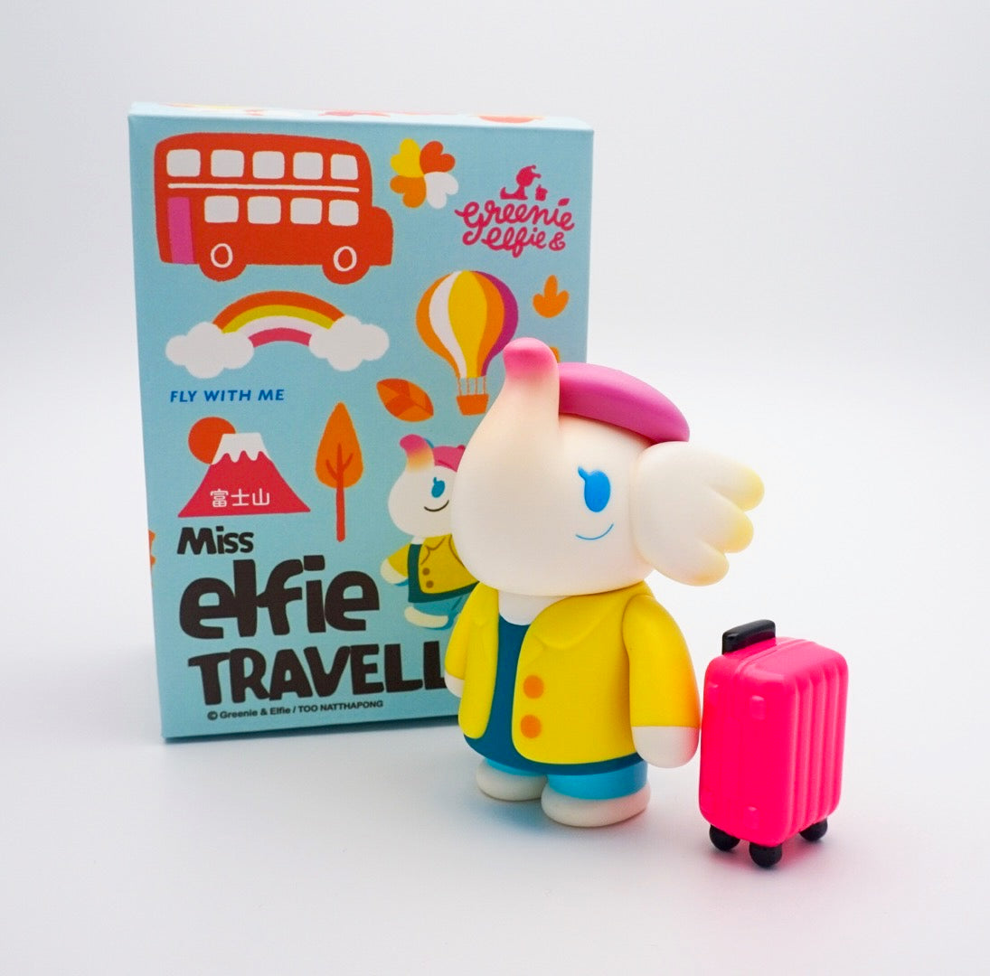 Toy elephant with a suitcase, toy figure in front of a box, pink hat and yellow coat, close-up of a pink object, blue drop of paint, colorful hot air balloon, pink ball, red double decker bus, and a close-up of a toy.