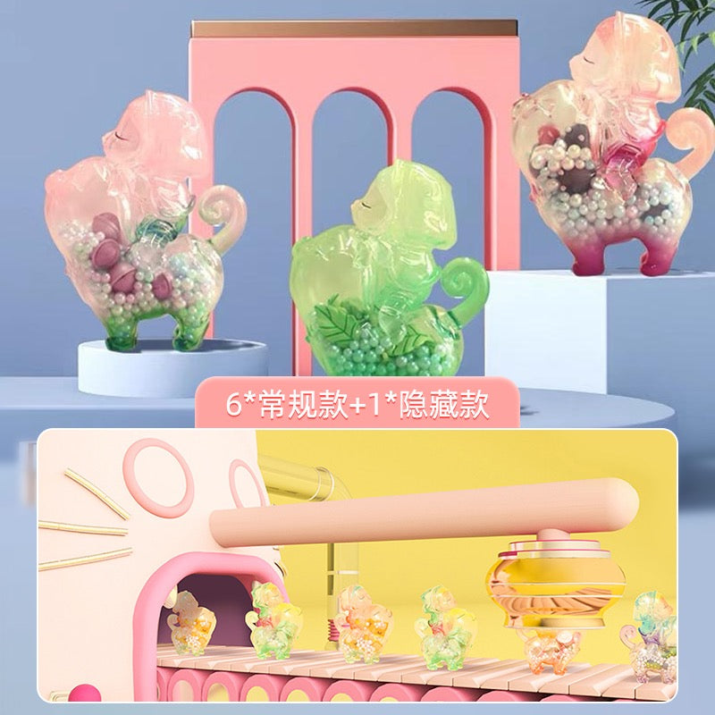 A group of toys including a green plastic animal, a pink cat figurine, and glass figurines from the Happy Capsule Blind Box Series by Kemelife.