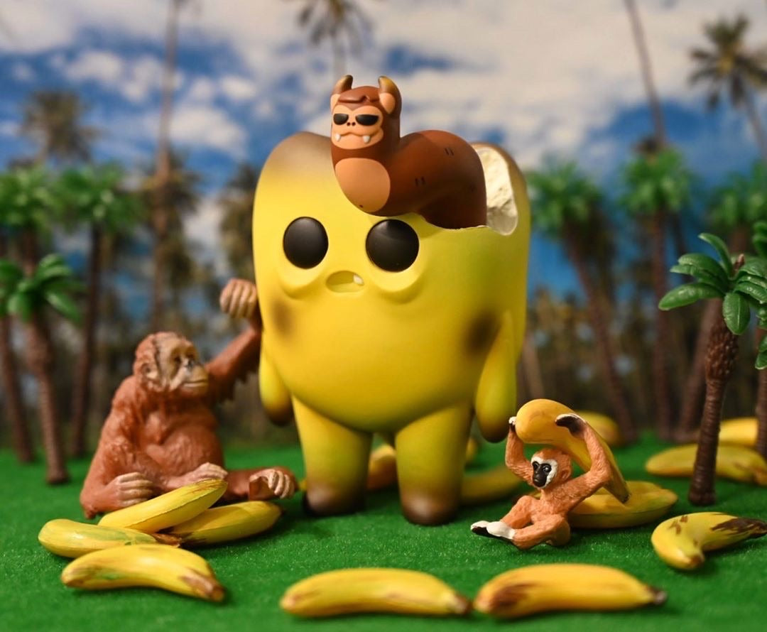 Toy figurine of a banana with monkeys, a monkey holding a banana, and a close-up of a banana, part of the Tooth Off Banana Tooth by Bear In Mind Toys collection.
