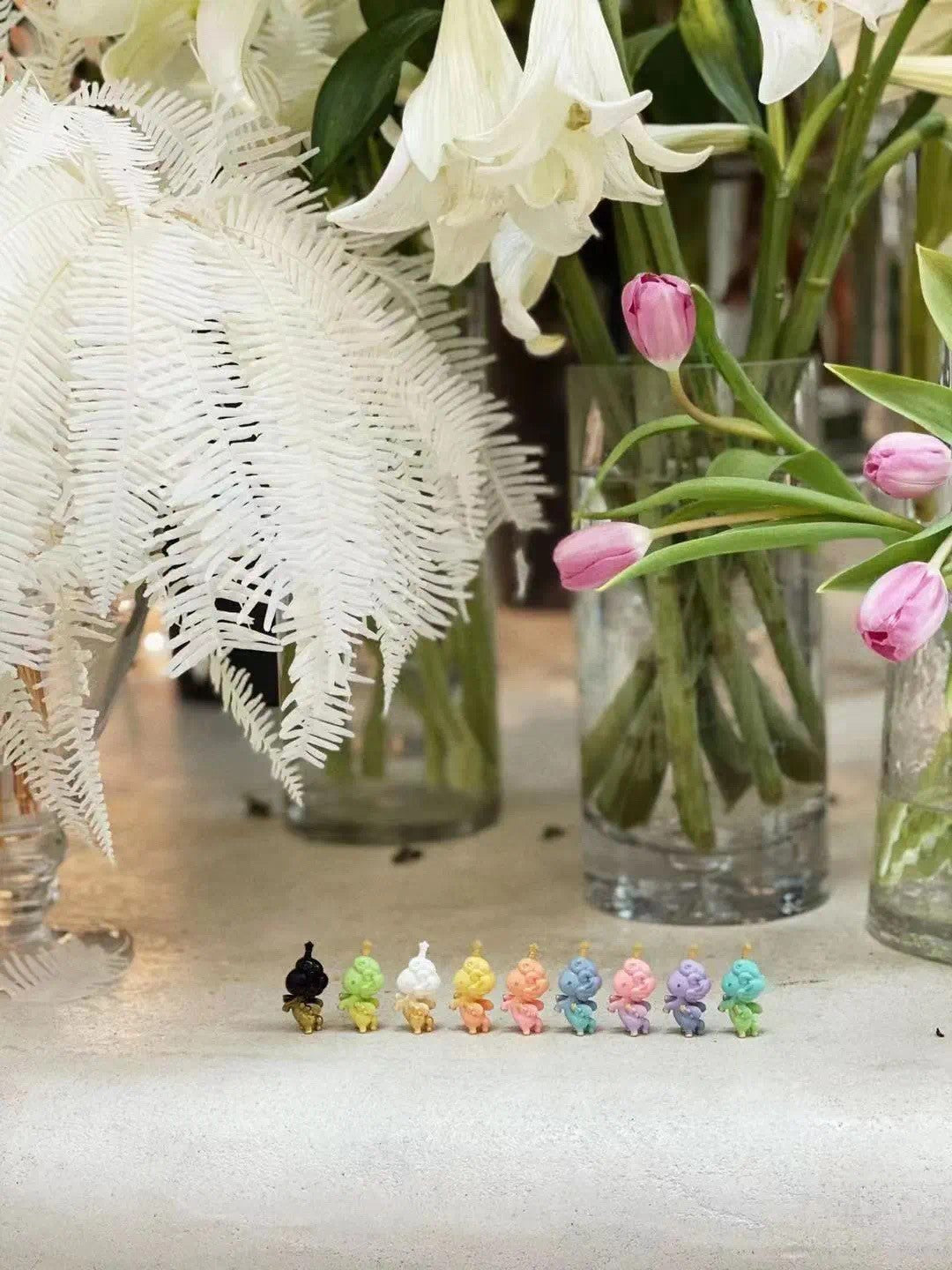 Motchi Unicorn Blind Eggs Series 2: Colorful figurines, vases of flowers, tulip in vase, baby doll, toy, stuffed animal.