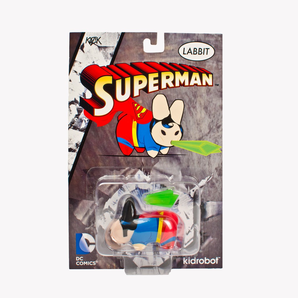 A superhero Labbit toy in packaging, featuring Superman with red cape and Kryptonite accessory, part of the DC Universe Labbit Blister Card figures by Kidrobot x Kozik.