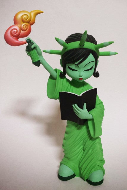 Statue of a woman holding a book and a gun, part of the Little Liberty Mint x Erick Scarecrow collection.