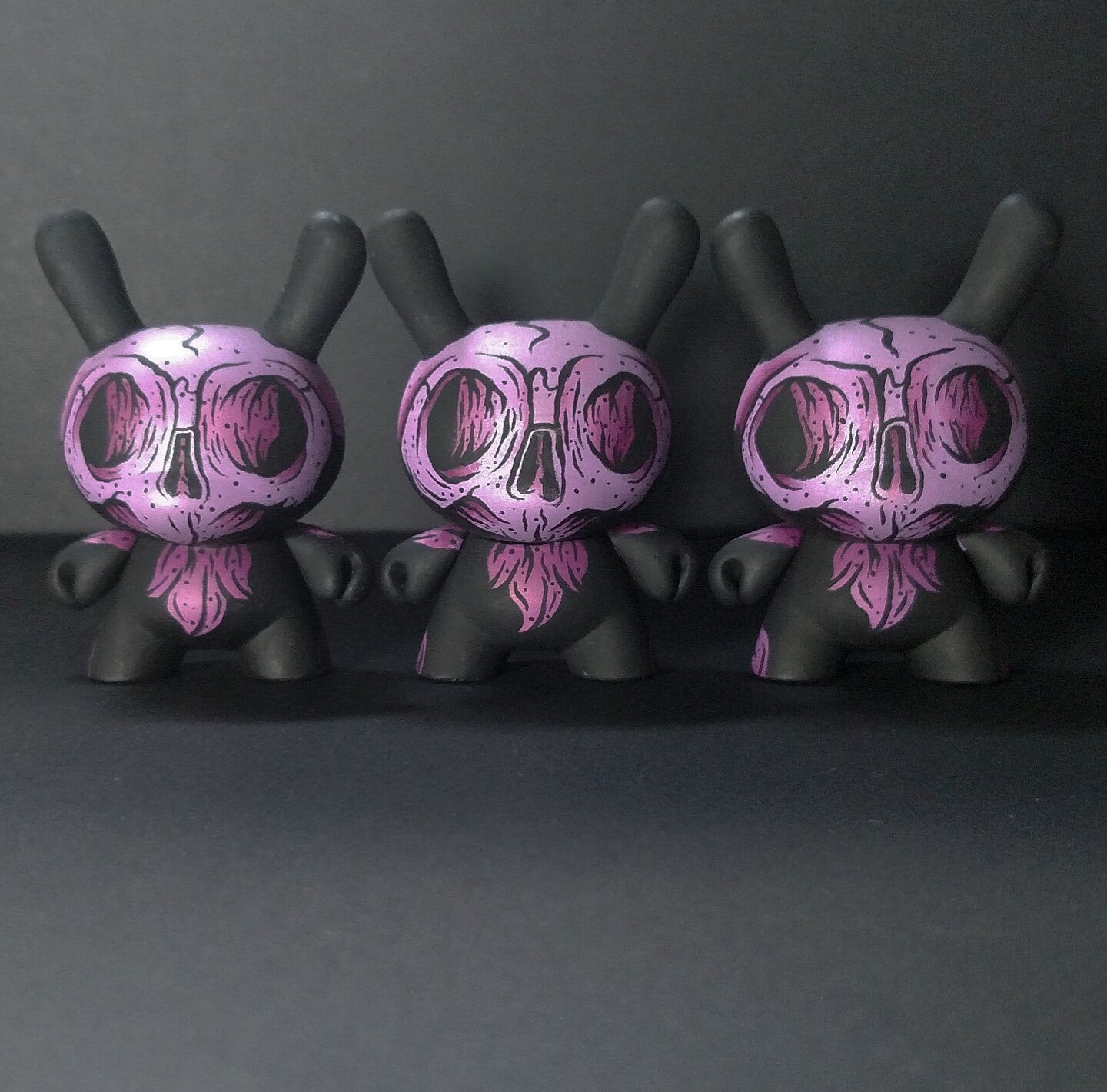 Group of small toys including a close-up of a skull and microphone, exclusive Atomic Fiend Dunnys by Cat Atomic.